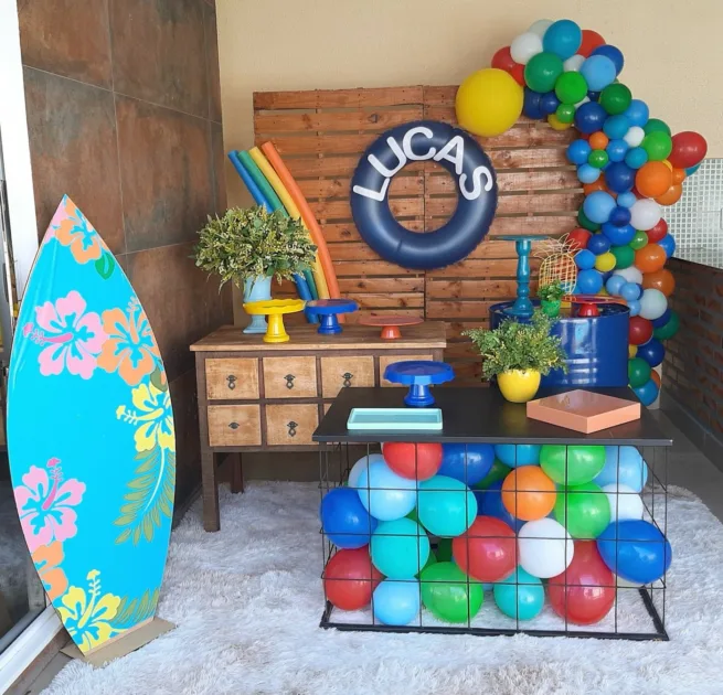 Beach Themed Birthday Inflatable With Name On Wood Backdrop And Surf Board Stand