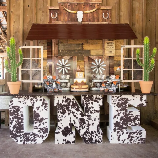 First Rodeo Birthday Party Large Cow Skin Print Letter Table Base And Wood Backdrop With Cactus Accents